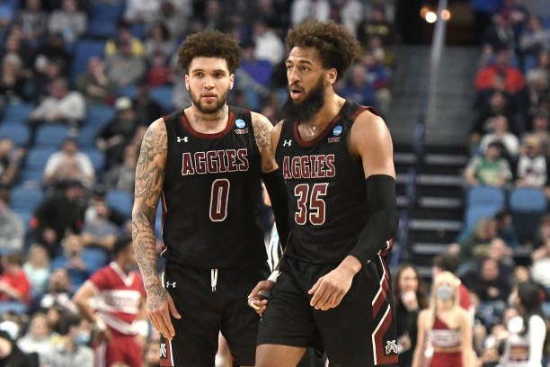 Teddy Allen and Johnny McCants of the New Mexico State Aggies chat during their 2022 NCAA Men's Basketball Tournament second-round game against...