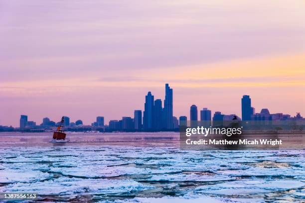 snow and ice cover lake michigan. the chicago city skyline as seen from navy pier. - chicago skyscraper stock pictures, royalty-free photos & images