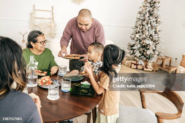 familia multiétnica comiendo pizza para el almuerzo - filipino family dinner fotografías e imágenes de stock