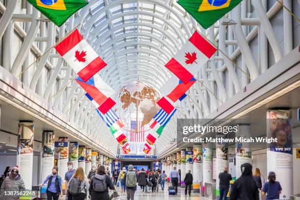 international flags fly in the chicago international airport or o'hare international airport. - ohare airport fotografías e imágenes de stock