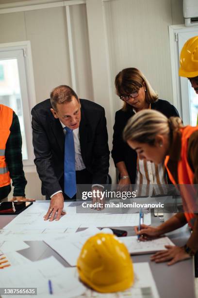 going through the construction plans - engineers brainstorming stock pictures, royalty-free photos & images