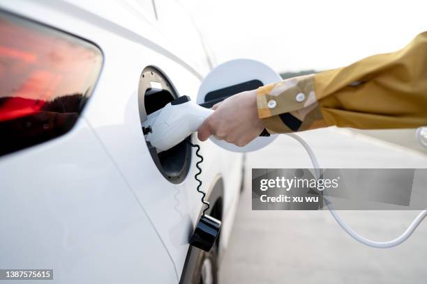 new energy vehicle handheld charging socket charging - elektrische auto stockfoto's en -beelden