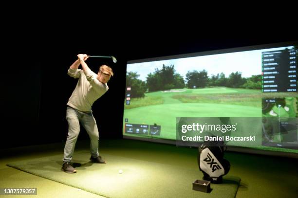 Guests compete in a golf simulator competition during the PXG Chicago West Grand Opening Celebration on March 24, 2022 in Chicago, Illinois.