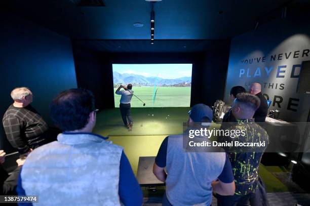 Guests compete in a golf simulator competition during the PXG Chicago West Grand Opening Celebration on March 24, 2022 in Chicago, Illinois.