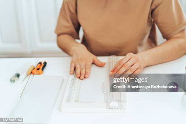 the girl at the white table cuts newsprint - kazakhstan market stock pictures, royalty-free photos & images