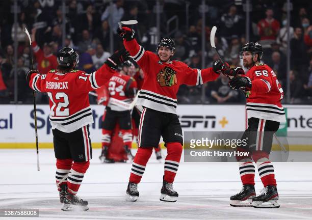 Alex DeBrincat of the Chicago Blackhawks celebrates his goal with Dylan Strome and Erik Gustafsson to clinch a 4-3 win over the Los Angeles Kings in...