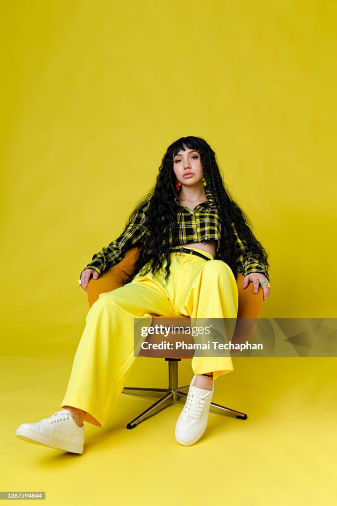 Fashionable woman standing against plain background