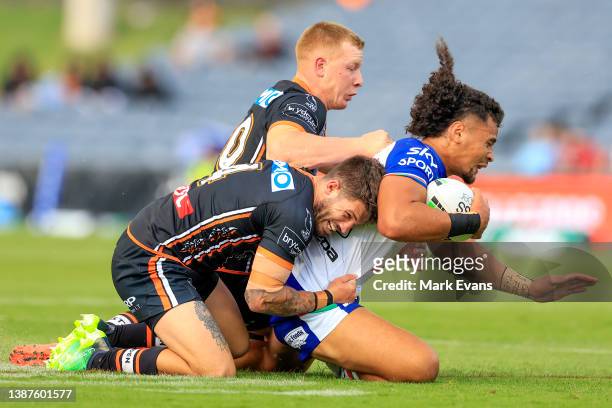 Eliesa Katoa of the Warriors is tackled during the round three NRL match between the Wests Tigers and the New Zealand Warriors at Campbelltown...