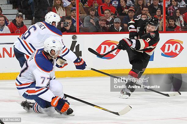 Milan Michalek of the Ottawa Senators fires a slap shot against Ryan Whitney and Tom Gilbert of the Edmonton Oilers at Scotiabank Place on February...