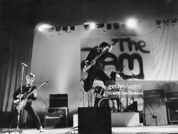 Paul Weller, Rick Buckler, Bruce Foxton performing live onstage, with The Jam logo on backdrop behind, 13th June 1977.