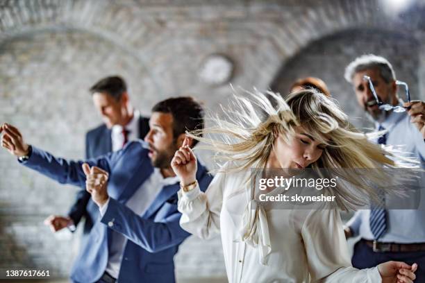 carefree businesswoman having fun while dancing at office party. - corporate party stock pictures, royalty-free photos & images