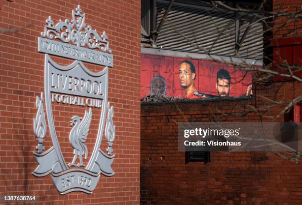 Poster of Virgil van Dijk peers over a wall outside the Anfield Stadium, home of Liverpool FC on March 24, 2022 in Liverpool, England.