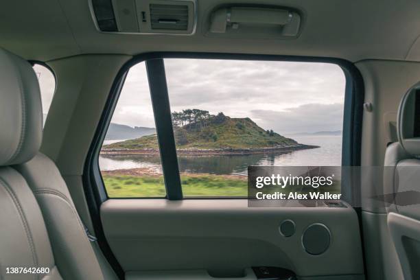view out of modern luxury car side window overlooking loch melfort in the scottish highlands. - car window stockfoto's en -beelden