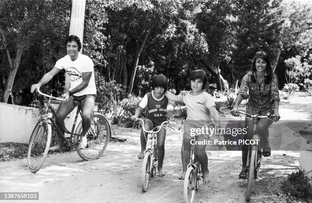 Sacha Distel avec sa femme Francine et leurs enfants à vélo à Rayol-Canadel-sur-Mer le 17 juillet 1975