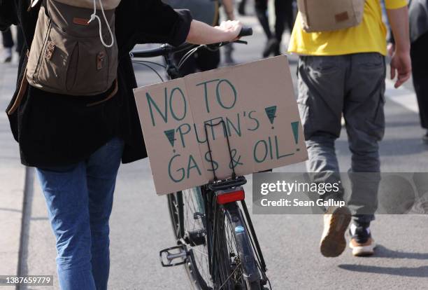 Supporters of the Fridays for Future climate action movement, including one holding a sign that reads: "No to Putin's Gas and Oil!", march as part of...