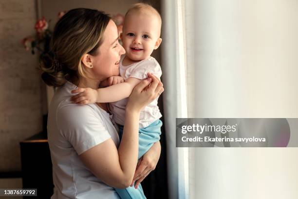 mom and little daughter at home. moments of tenderness and love. - mother in law ストックフォトと画像