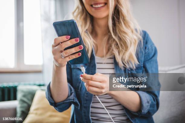 woman charging power to smart phone. - plug in stock pictures, royalty-free photos & images