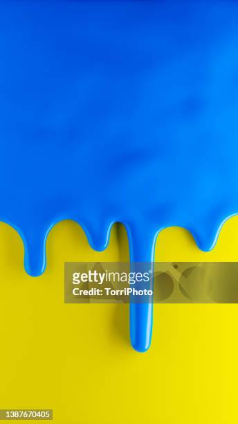 glossy blue paint flows over yellow background - slime stockfoto's en -beelden