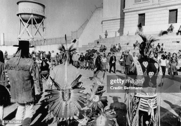 Occupants on Alcatraz Island, gather in front of the main cell block with the island's water tower in the background, during the occupation of...