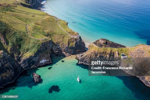 uk, northern ireland, county antrim, ballintoy, carrick-a-rede rope bridge, aerial drone view - northern ireland rope bridge stock-fotos und bilder