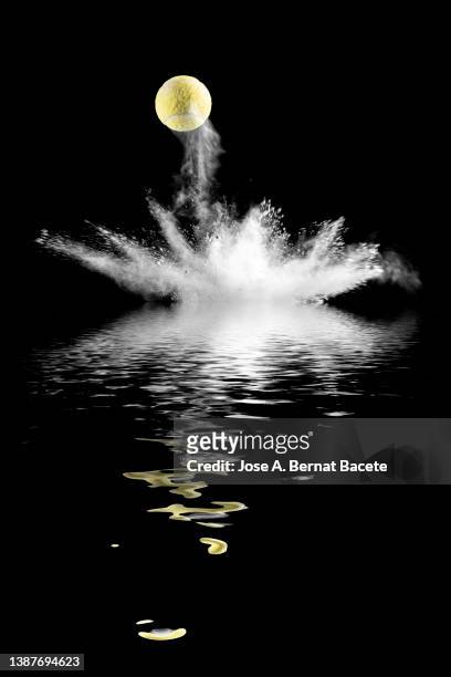 impact and rebound of a tennis ball on the ground, reflected on a water surface. - 1 etappe stock-fotos und bilder