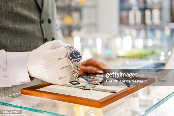 unrecognizable person holding and selling luxury watches - moment collection stockfoto's en -beelden