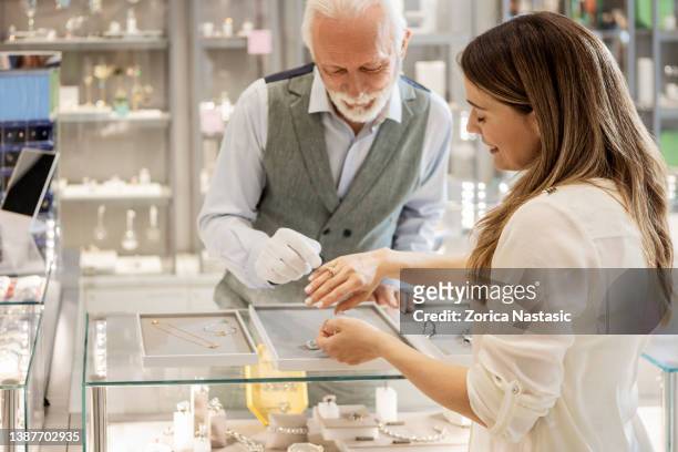 young woman trying on a diamond ring - jeweller stock pictures, royalty-free photos & images