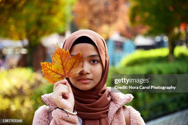 teen with autumn leaf cover her face - young leafs stock pictures, royalty-free photos & images