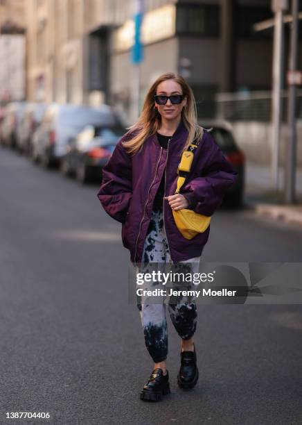 Sonia Lyson seen wearing a yellow Prada iPhone case, Prada yellow triangle leather bag, The Frankie Shop purple berry bomber jacket, Prada black...