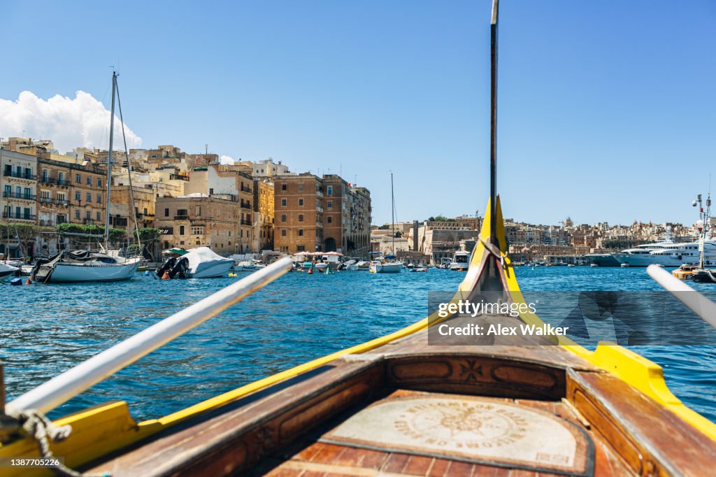 Bow of traditional wooden water taxi crossing harbour to the Three Cities in, Malta