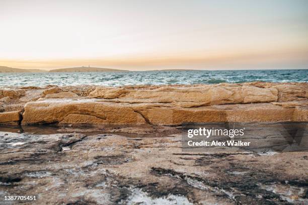 harbour wall with turquoise ocean at sunset in bugibba bay, malta. - maltese islands stockfoto's en -beelden