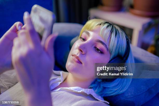 beautiful teenage girl standing next to neon light  and listening music - futurism stock pictures, royalty-free photos & images