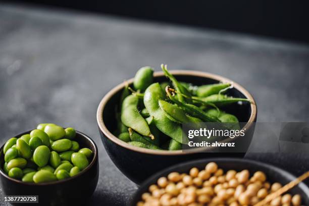 close-up of healthy raw beans in ceramic bowls - bolster stockfoto's en -beelden