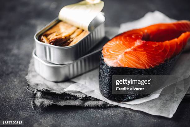 raw salmon steak with canned sardine - frozen fish fillets stockfoto's en -beelden