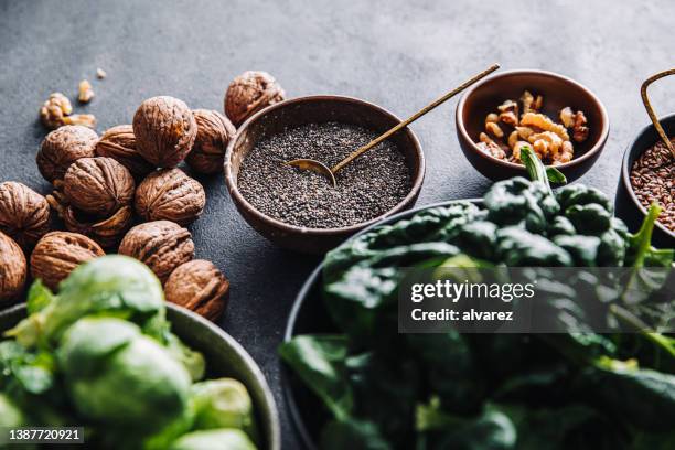 primer plano de comida vegana omega 3 en cuencos sobre mesa negra - semilla-de-lino fotografías e imágenes de stock