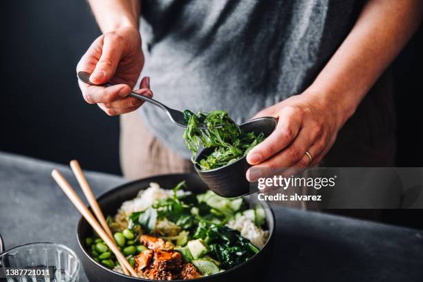 gros plan d’une femme mangeant une salade riche en oméga 3 - bowl photos et images de collection