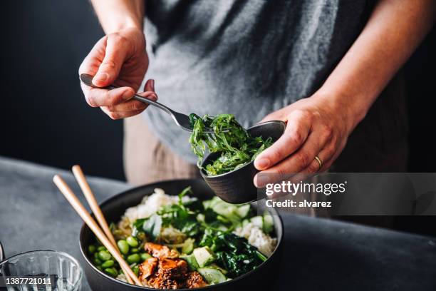 close-up of woman eating omega 3 rich salad - poke food stock pictures, royalty-free photos & images