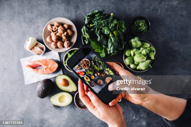 woman photographing healthy omega 3 rich food ingredients - omega 3 fish stock pictures, royalty-free photos & images