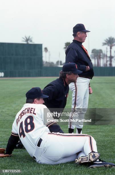 American baseball player Rick Reuschel , on the San Francisco Giants, takes a break with two unidentified members of the team's coaching staff prior...