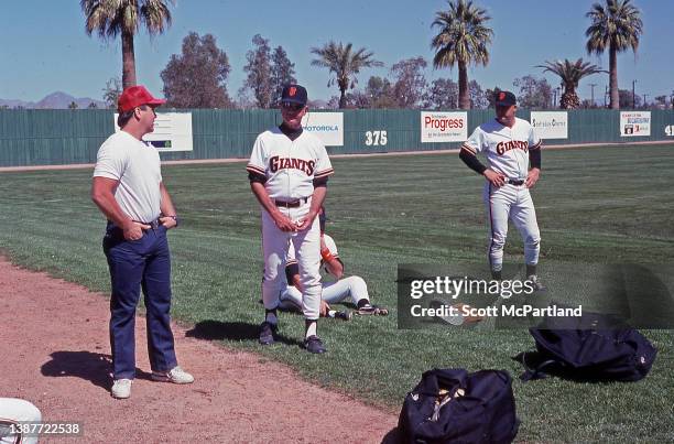 Unidentified members of the San Francisco Giants coaching staff chat prior to a Cactus League game during spring training at Scottsdale Stadium,...