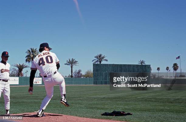 American baseball player Bud Black , of the San Francisco Giants, warms up, as an unidentified member of the pitching staff watches, prior to a...