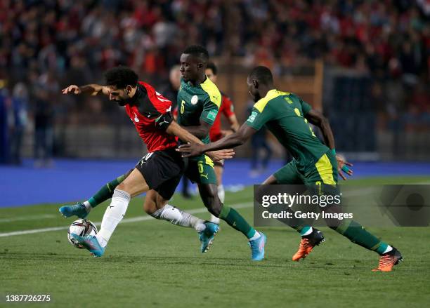 Mohamed Salah of Egypt is tackled by Idrissa Gueye and Saliou Ciss of Senegal during the FIFA World Cup Qatar 2022 qualification match between Egypt...