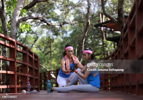 frauen in der energie, gesunde frauen trainieren morgens im mangrovenwald, fitnesstrainer bringen einem mädchen kraftübungen per hantel bei - chubby asian girl stock-fotos und bilder
