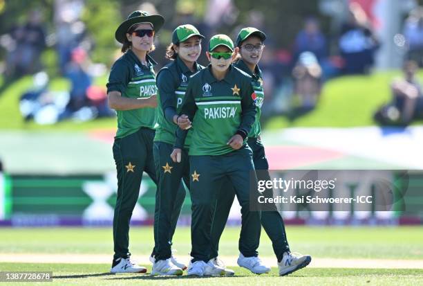 Anam Amin of Pakistan celebrates with teammates after bowling out Sophie Devine of New Zealand during the 2022 ICC Women's Cricket World Cup match...