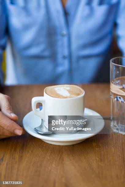 high angle view of coffee cup with froth art on wooden table - pires - fotografias e filmes do acervo