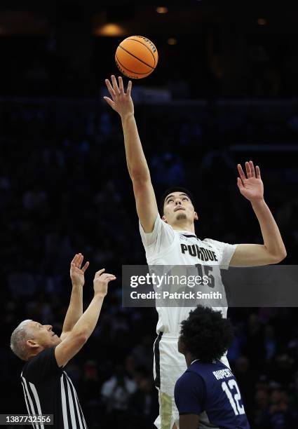 Zach Edey of the Purdue Boilermakers wins the opening tip-off against Clarence Rupert of the St. Peter's Peacocks in the Sweet Sixteen round game of...