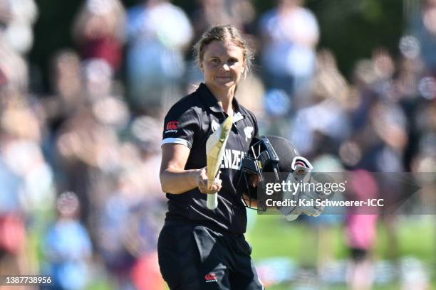 Suzie Bates of New Zealand raises her bat after scoring a century during the 2022 ICC Women's Cricket World Cup match between New Zealand and...