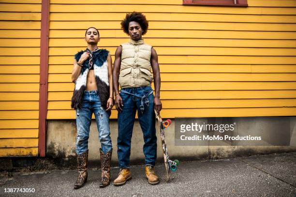 portrait of fashionable young couple in front of yellow urban home - cowboystövlar bildbanksfoton och bilder