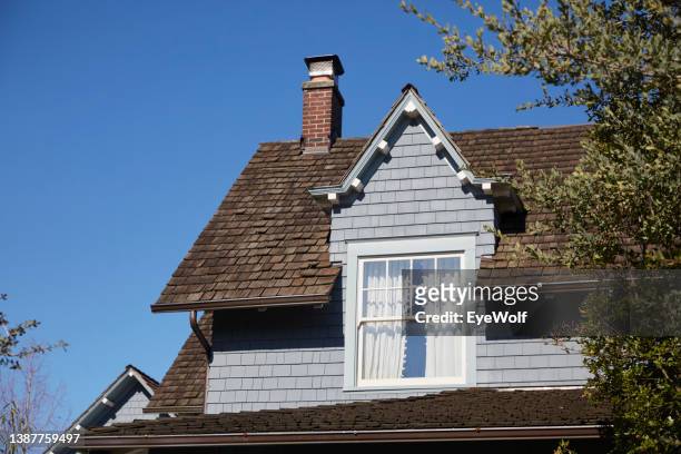 roof shingles and clear blue sky. victorian style house - gordelroos stockfoto's en -beelden