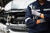Hand of car mechanic with wrench. Auto repair garage. mechanic works on the engine of the car in the garage. Repair service. Concept of car inspection service and car repair service.